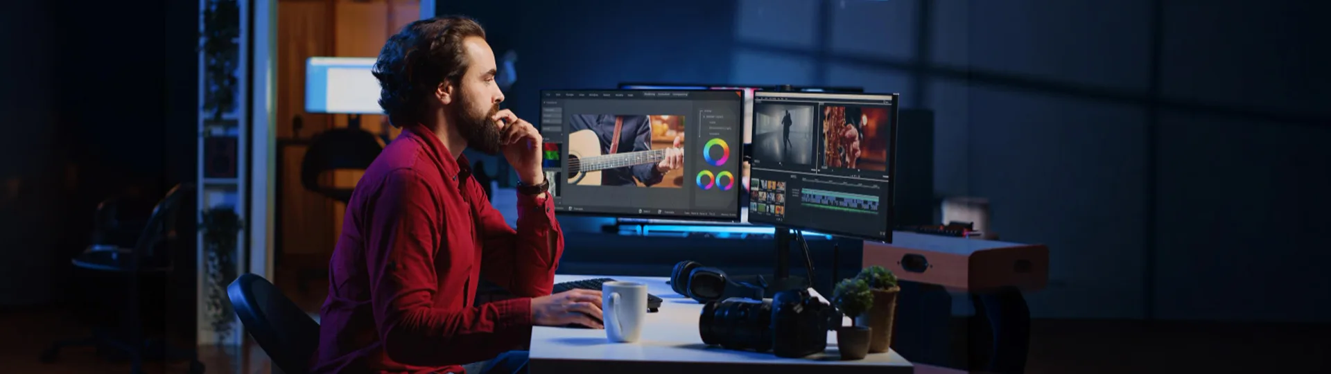Editor at a desk reviewing colour grading and a video timeline across two monitors in a dim studio