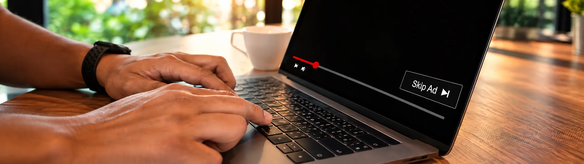 Hands on a laptop keyboard while a video ad plays with a Skip Ad button on screen